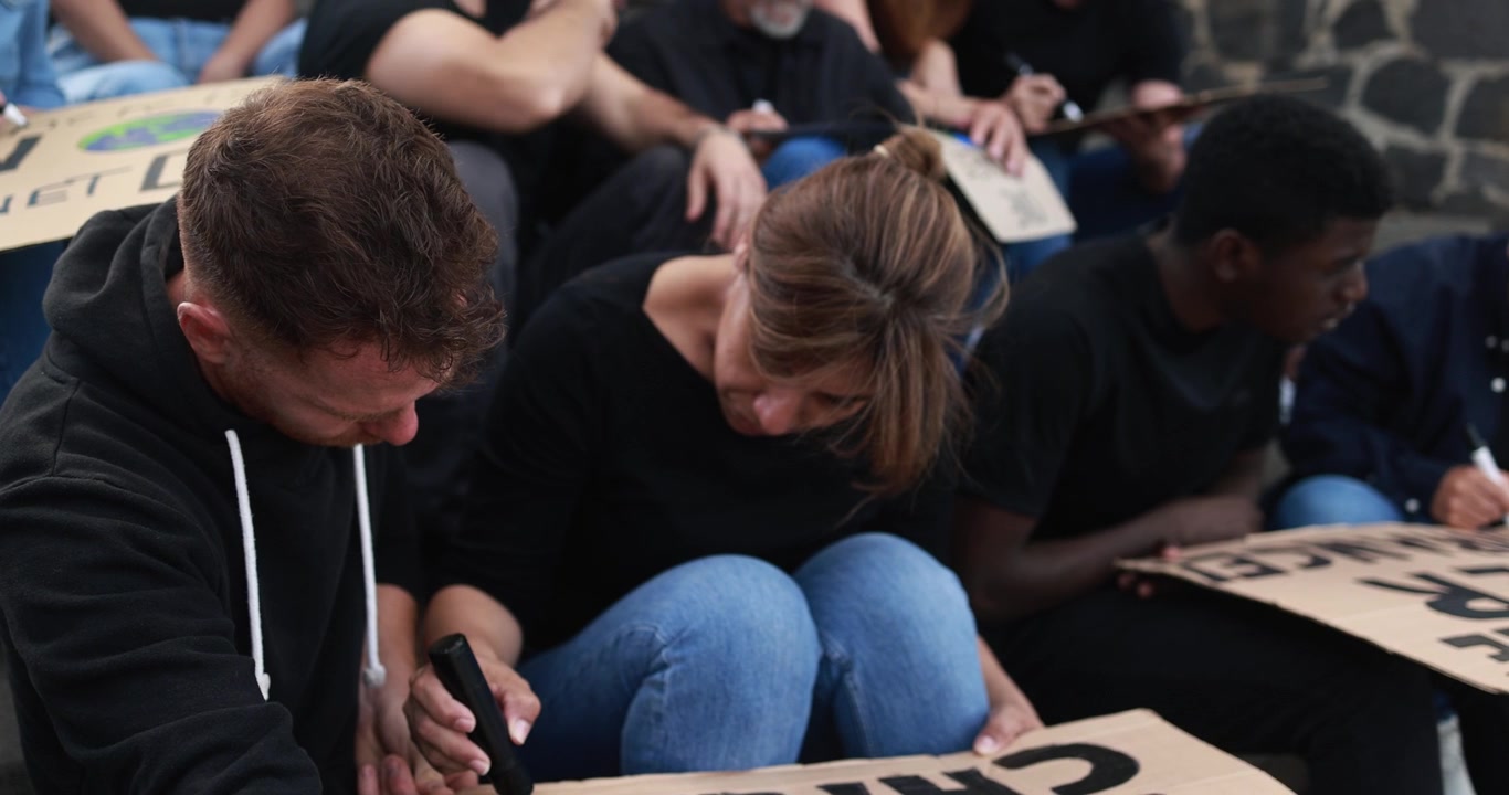 Attivisti che preparano cartelli di protesta per una manifestazione sul cambiamento climatico