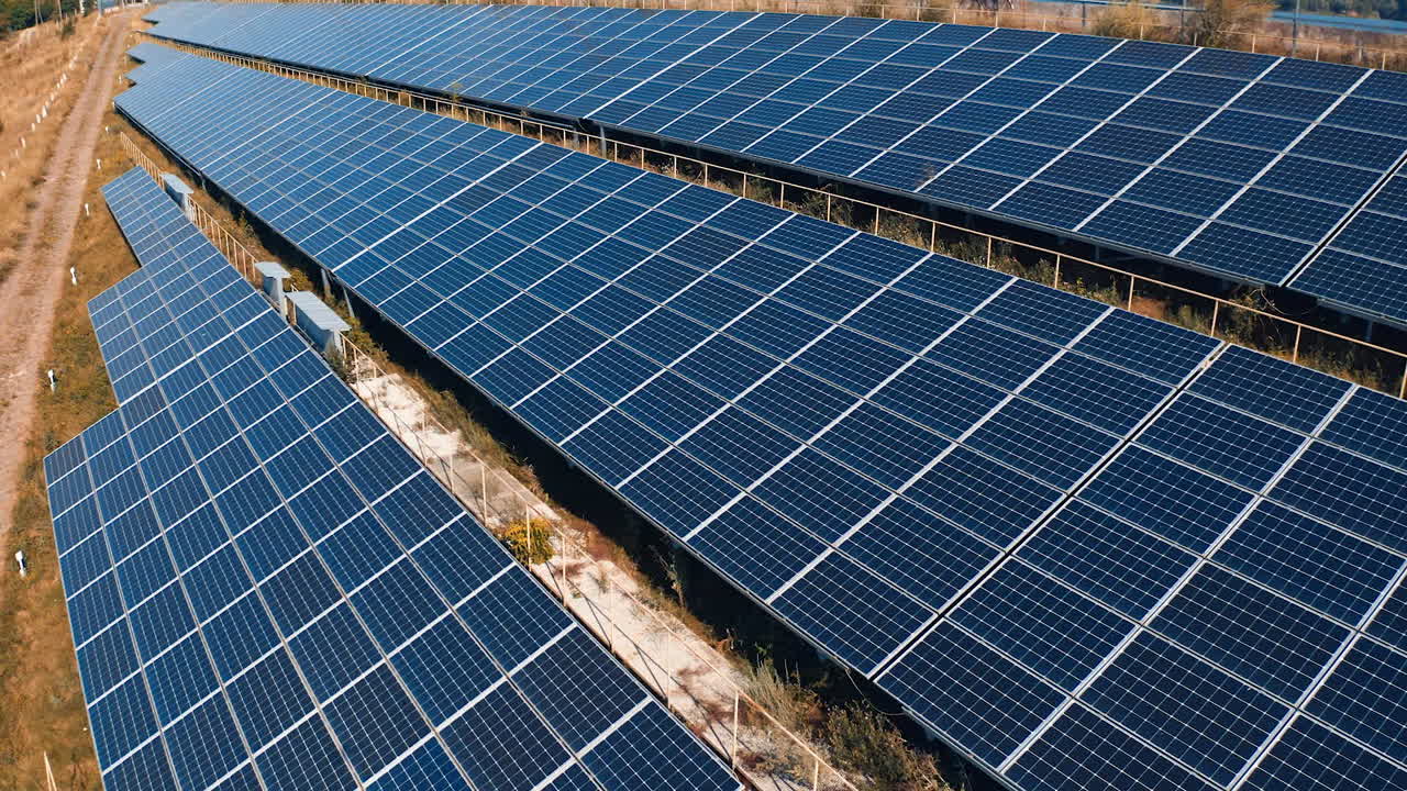 Photovoltaic panels at sunlight. Blue solar panels on the ground. Alternative source of clean energy from the sun. Drone flight.