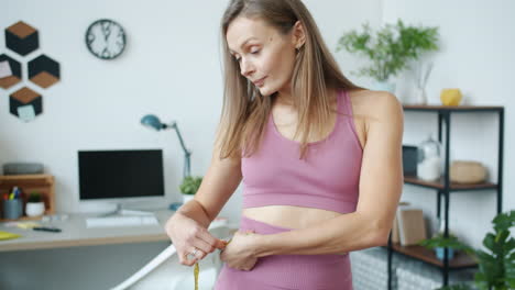 woman measuring her waist at home