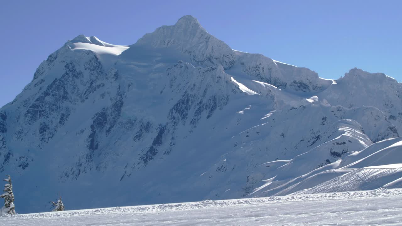 increíble fondo de pico de montaña con snowboarder tallando en cámara lenta