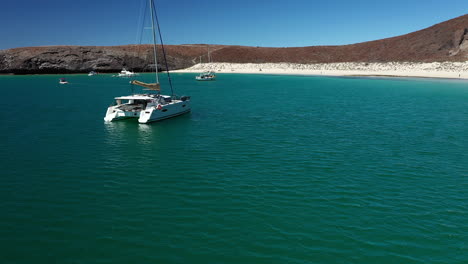 barcos a la deriva frente a la costa de arena blanca de playa balandra en la paz, méxico