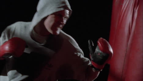 un hombre golpea un saco de boxeo 7