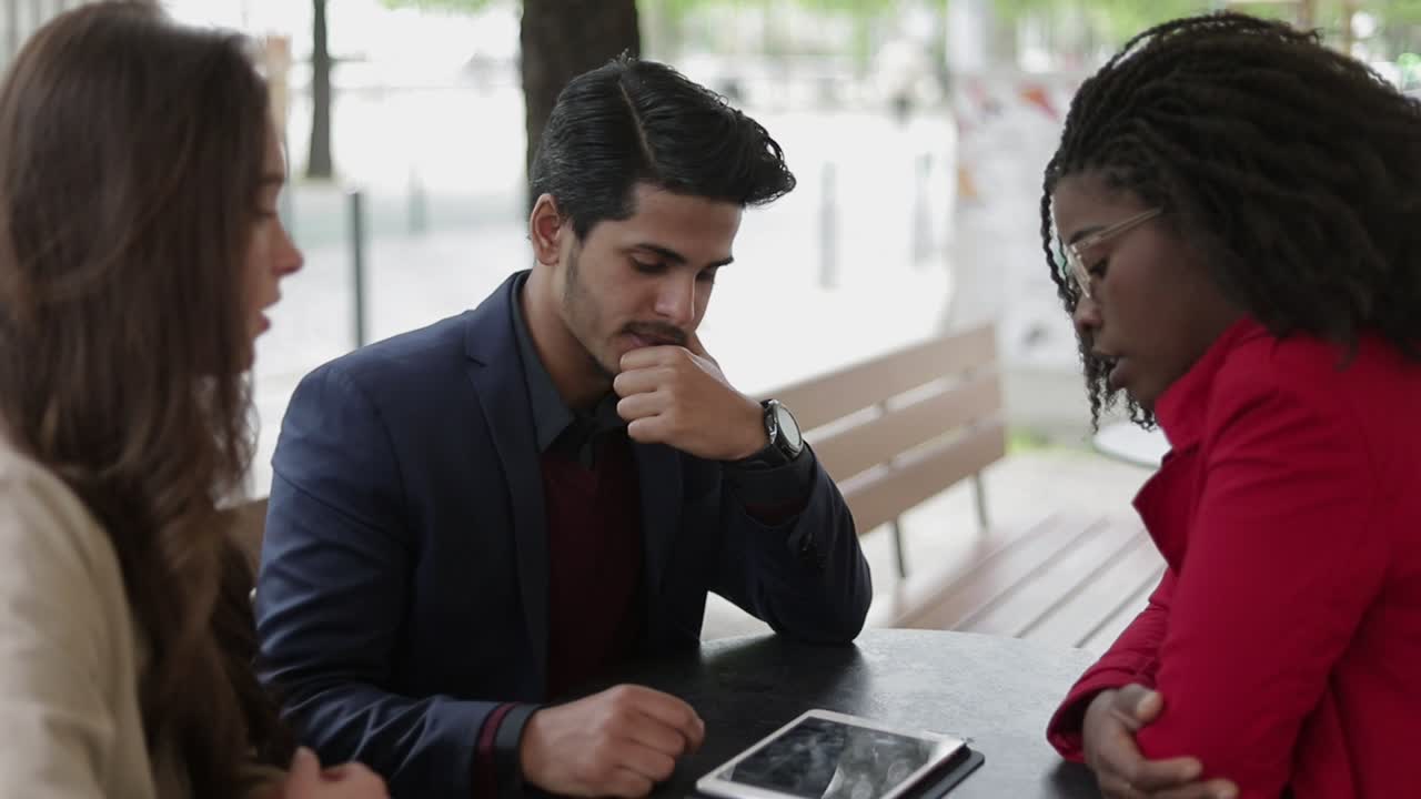 una pareja joven discutiendo variantes después de ver fotos en la tableta.