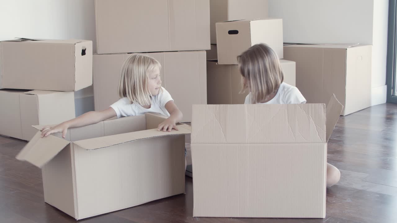 Sweet pretty girls unpacking things in new apartment