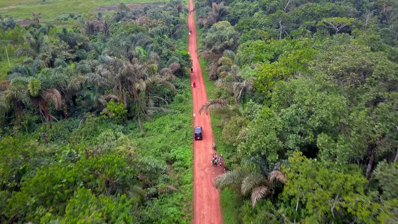 Vehicles Driving On A Dirt Road In Mukono, Uganda - Drone Shot
