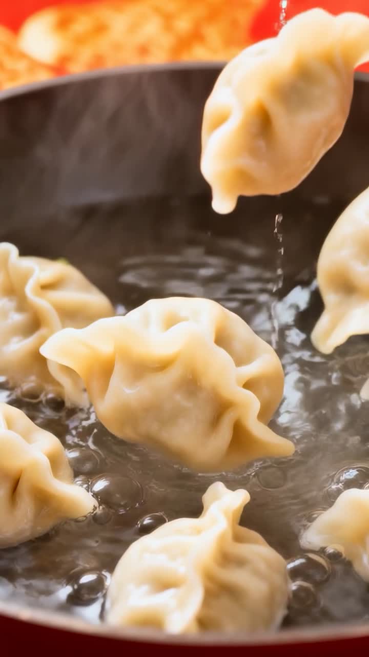 Video verticale: Acqua bollente fa galleggiare dei fagottini piegati e gocciolare gocce in una pentola di metallo casalinga.