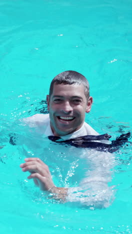 hombre de negocios vestido en la piscina