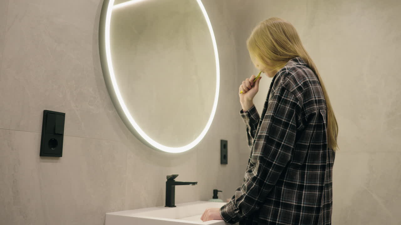 Donna che si lava i denti in un bagno moderno