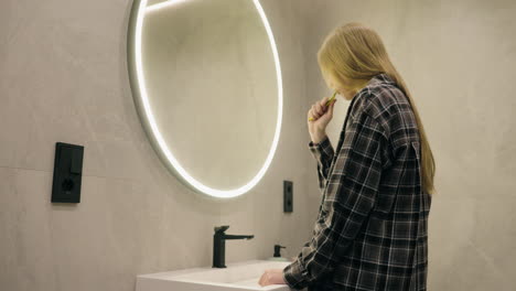 woman brushing teeth in modern bathroom