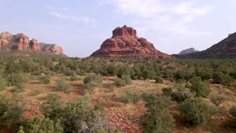 rising aerial, bell rock mountain formation on a clear morning with blue skies, sedona arizona