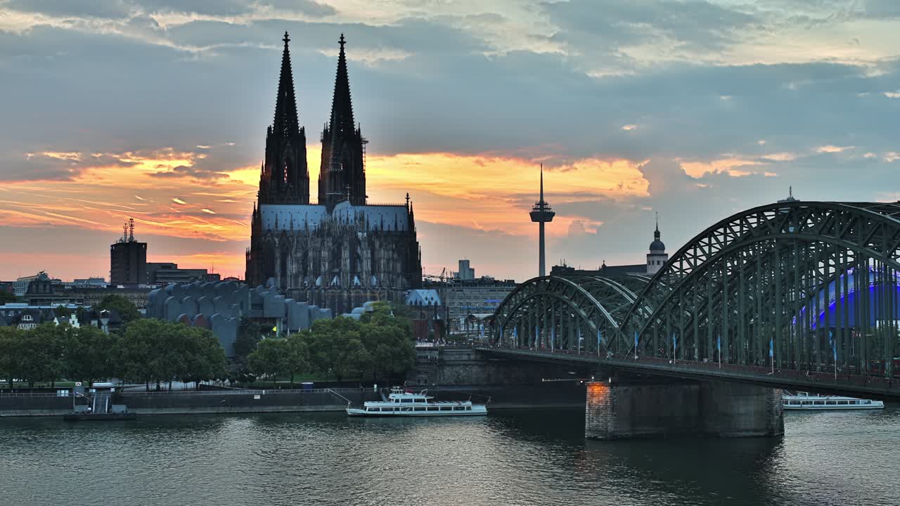 Timelapse of Cologne central cathedral with clouds passing by at river rhine hohenzollern bridge at sunrise