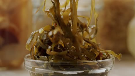japanese wakame sea weed laminaria chuka fermented food. close-up on a detail of hiyashi wakame chuka or seaweed salad or seaweed with sesame seeds on a plate. top view. seafood background.