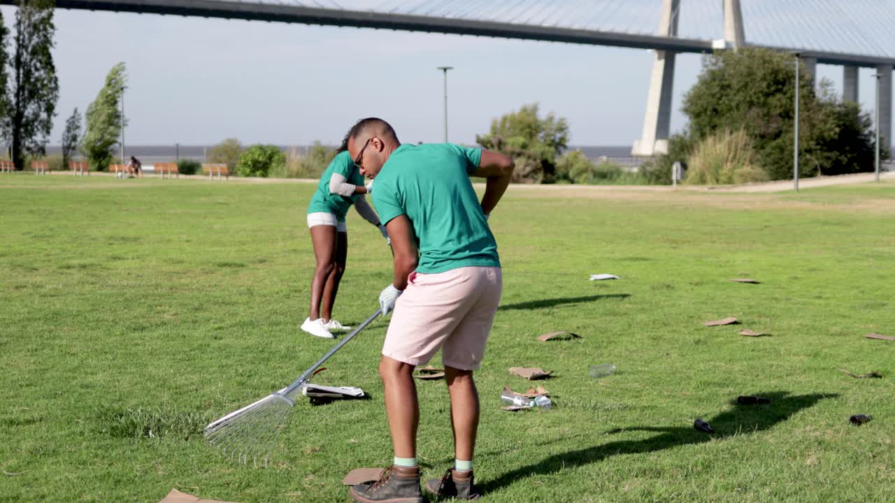 자원 봉사자 들 이 공원 에서 쓰레기 를 모으고 있다