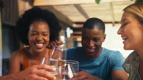 Close-Up-Of-Smiling-Multi-Cultural-Friends-Outdoors-At-Home-Drinking-Wine-Together