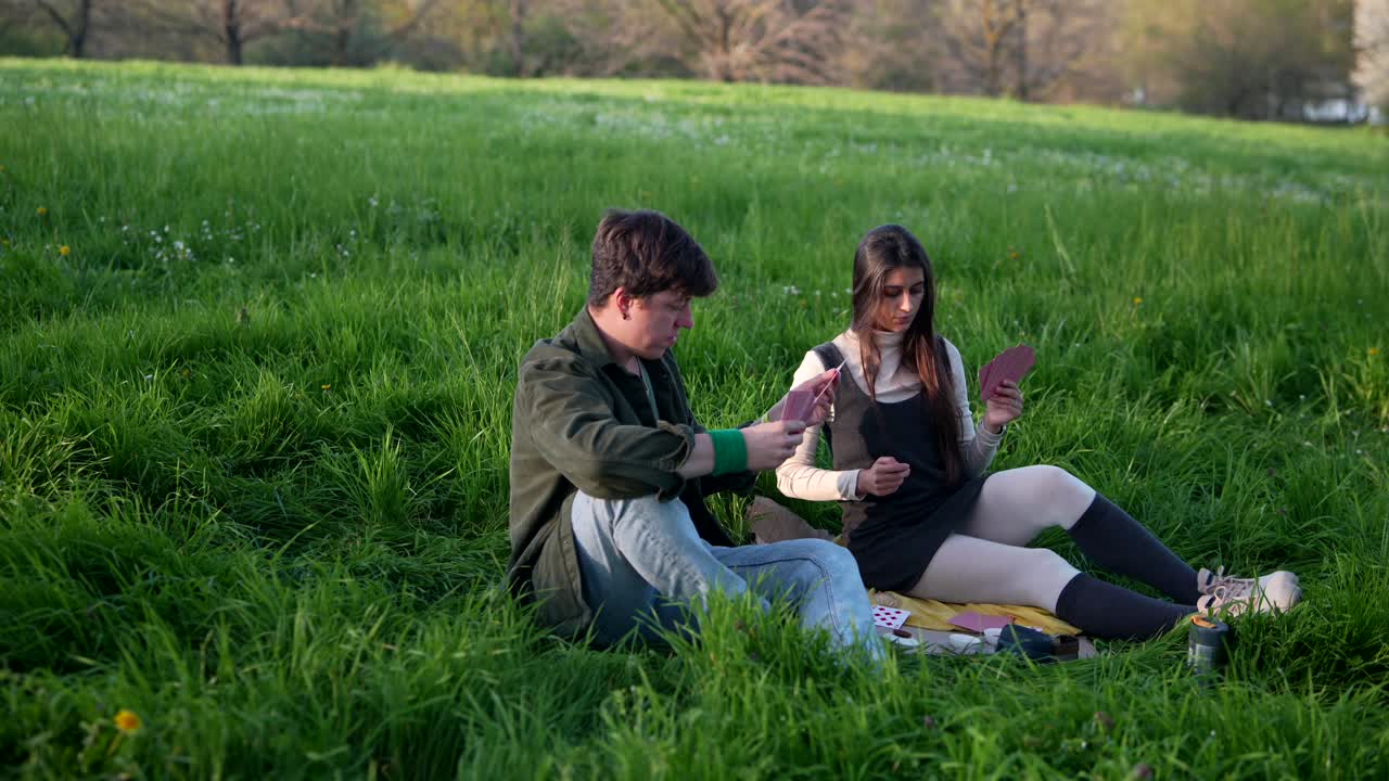Couple Playing Cards in a Park