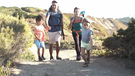 active parents and kids walking on path downhill