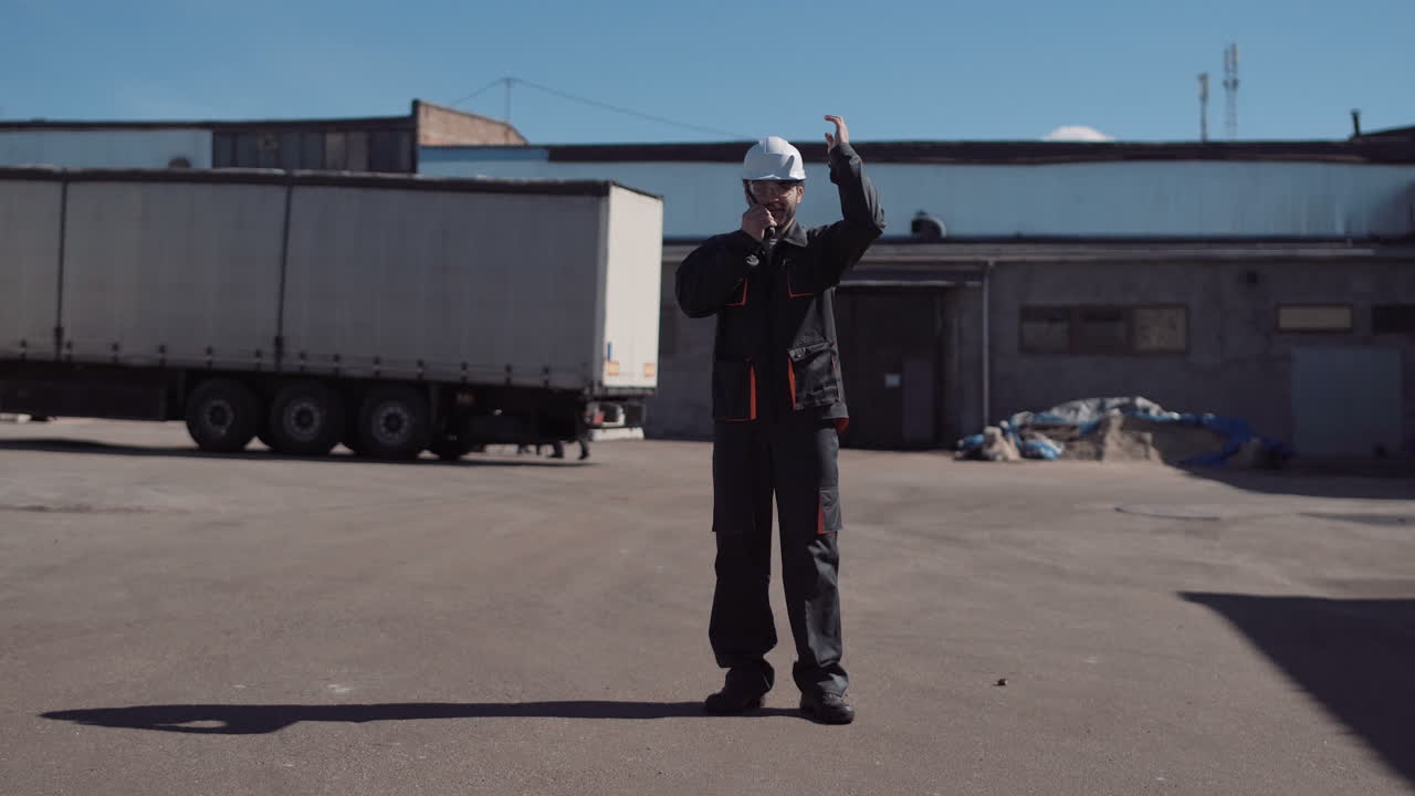 Industrial worker communicating with a radio at a truck yard