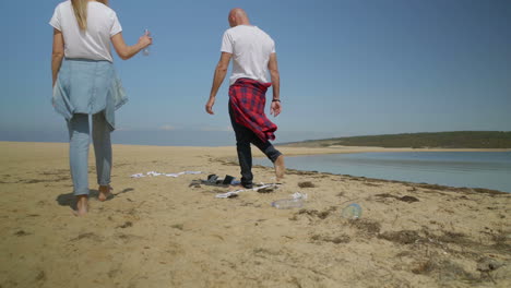 Pareja-Caminando-Por-La-Playa-Llena-De-Basura