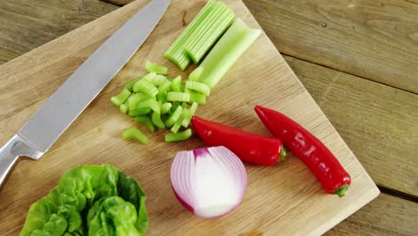 vegetables and kitchen knife on chopping board