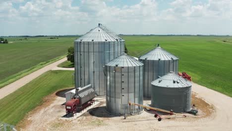 survol aérien de l'agriculture conteneurs de silos à grains sur un champ agricole rural