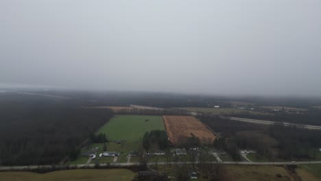 An-aerial-shot-flying-over-the-countryside-heading-in-to-a-thick-heavy-fog-over-I80