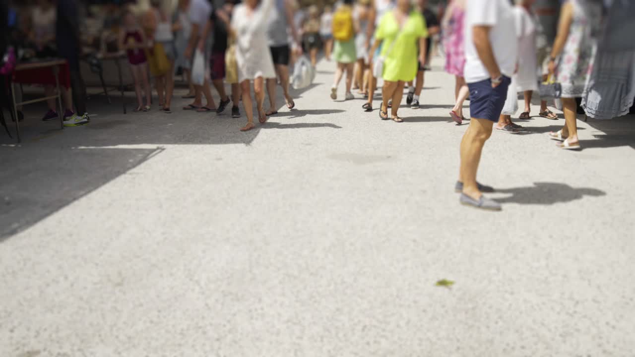 Moving down the main aisle of the market of Cala De Mijas on the Costa Del Sol in Southern Spain. A gradient blur filter subtly hides the faces of the shoppers