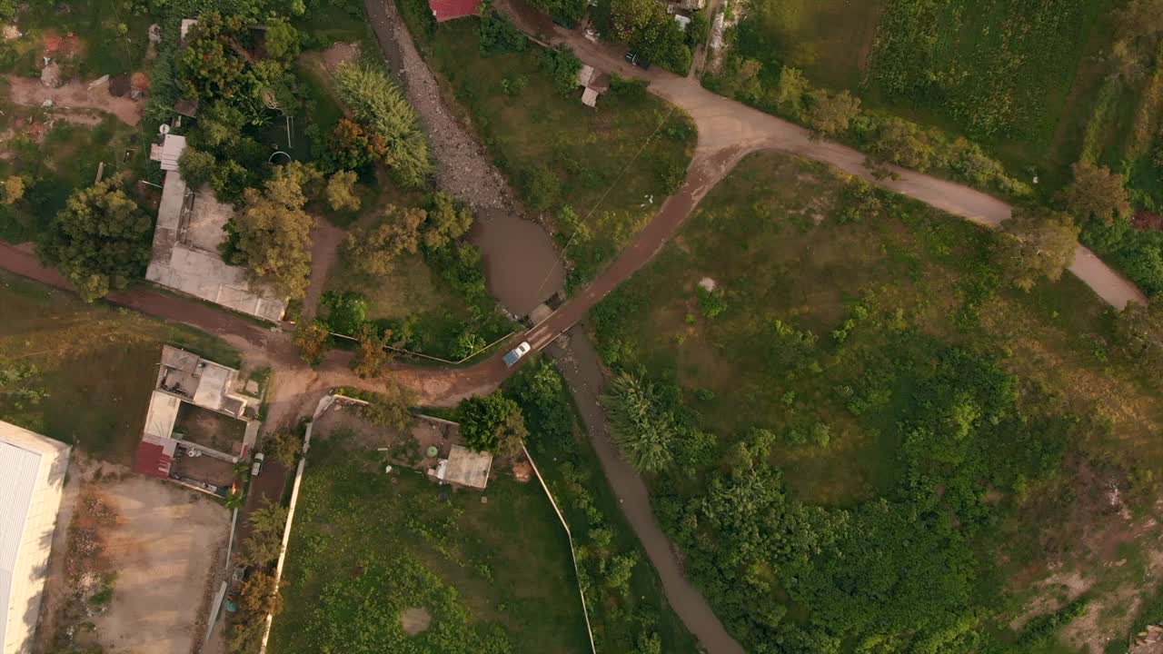 antena: coche pasando por un puente en un barrio pobre de méxico
