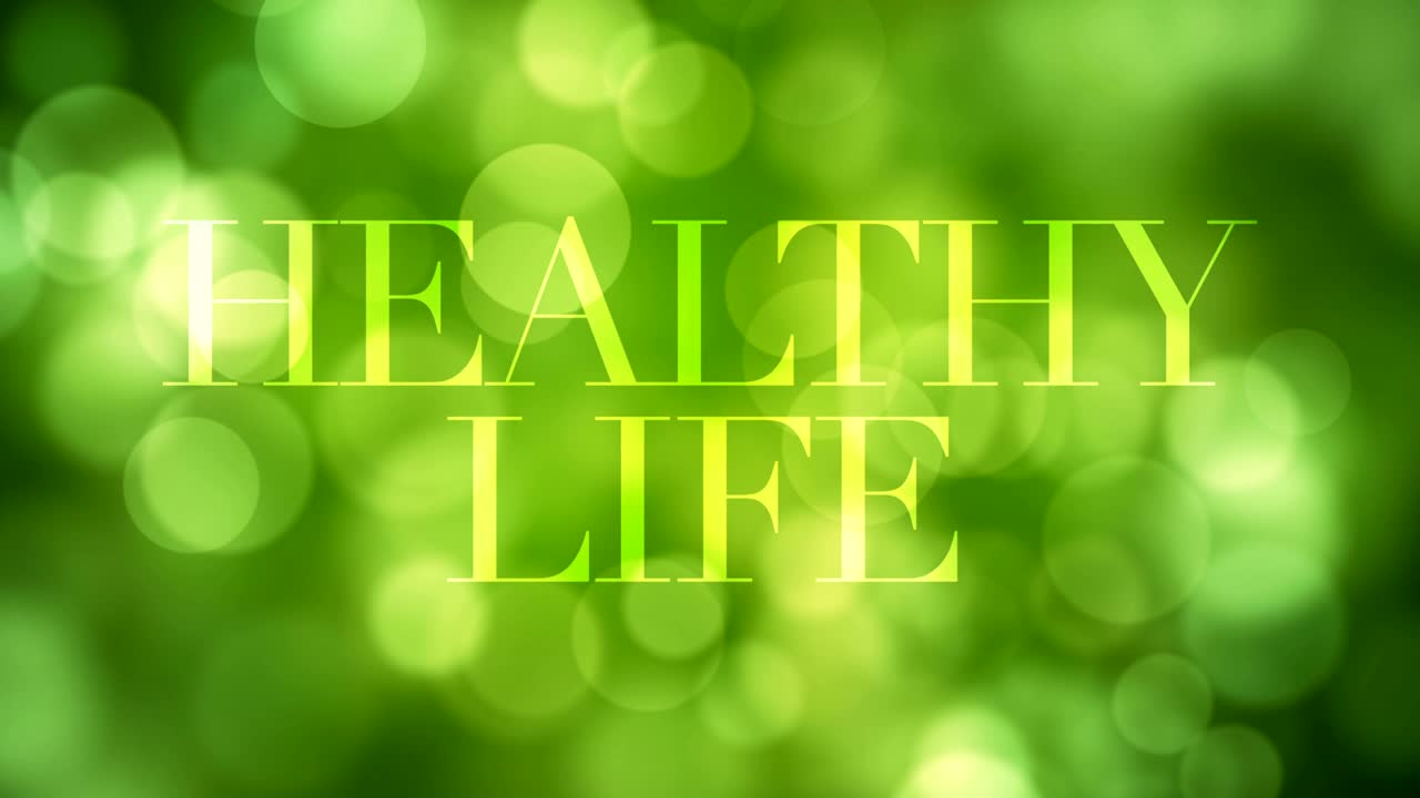 '건강한 삶' 텍스트가 나타나고 잠시 후에 녹색 반이는 빛과 함께 녹색 보케 배경에 초점을 맞추지 않은 빛 반사입니다. 건강한 삶, 봄, 숲 개념 비디오