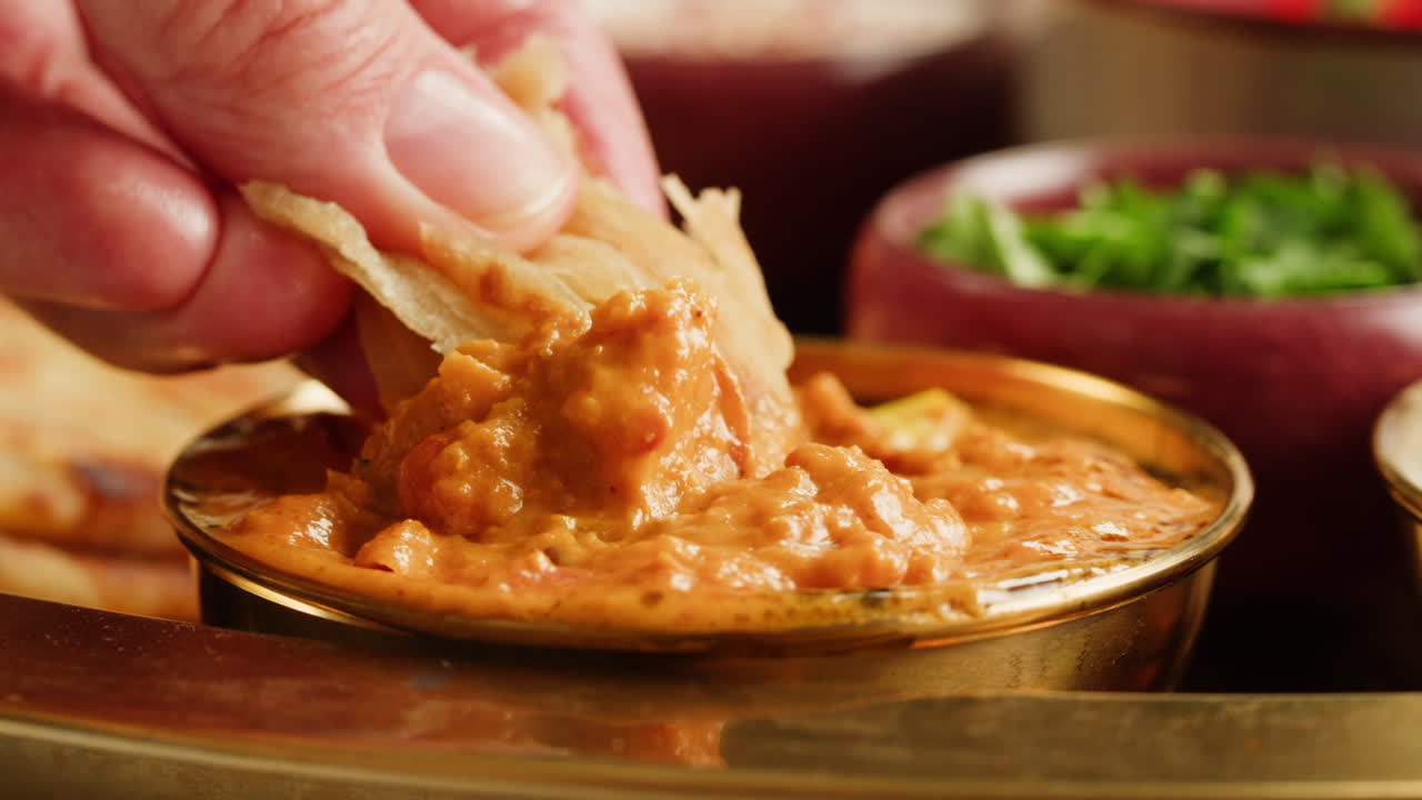 Assorted indian sri-lanka food set on wooden background. Dishes and appetisers of indeed cuisine, rice, lentils, paneer, samosa, spices, masala. Bowls and plates with indian food top view chicken. High quality 4k footage