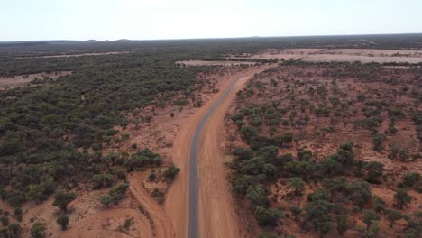 Vista-Aérea-De-Una-Carretera-Rural-Rodeada-De-Tierra-Roja-En-El-Interior-De-Australia