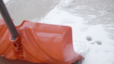 Shovel Scooping Up Snow Along Pavement