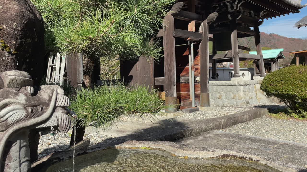 日本の山中にある仏教寺院の手水舎の龍の噴水鉢。