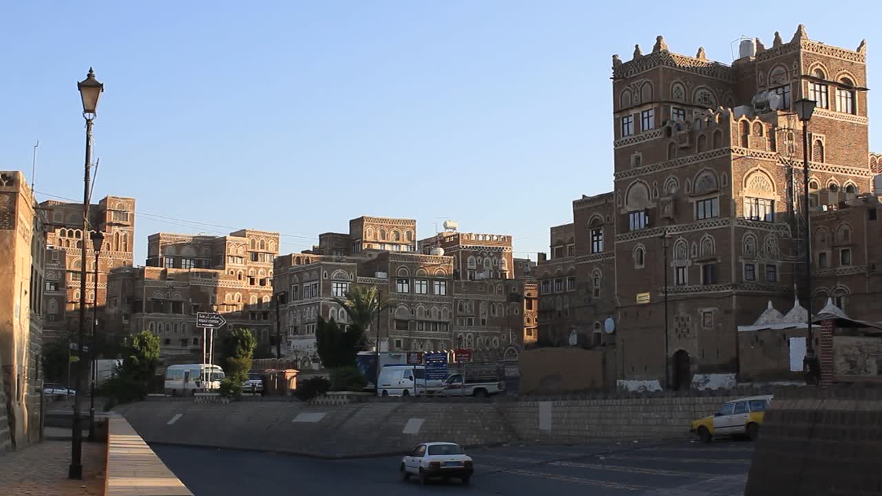 Wide shot of Old Sana'a city street made of Rock and the Sun barely rising.