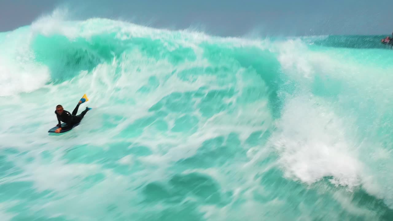 Slow motion aerial of bodyboarder close up surf on wave, Jervis Bay, Australia. Water sports slowmo