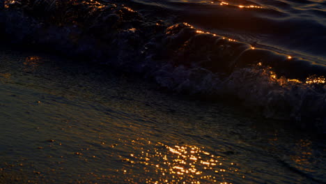 Agua-Oscura-Del-Océano-Rompiendo-La-Playa-De-Arena-En-La-Noche-Del-Atardecer.-Olas-Del-Mar-En-Calma-Salpicando