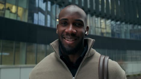 smiling man in front of modern office building