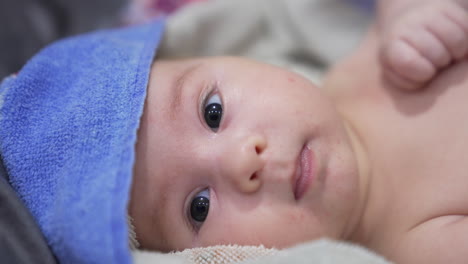 beautiful child's face in towel after bath time. close up. healthy and clean caucasian boy stays calm and peaceful after being washed.