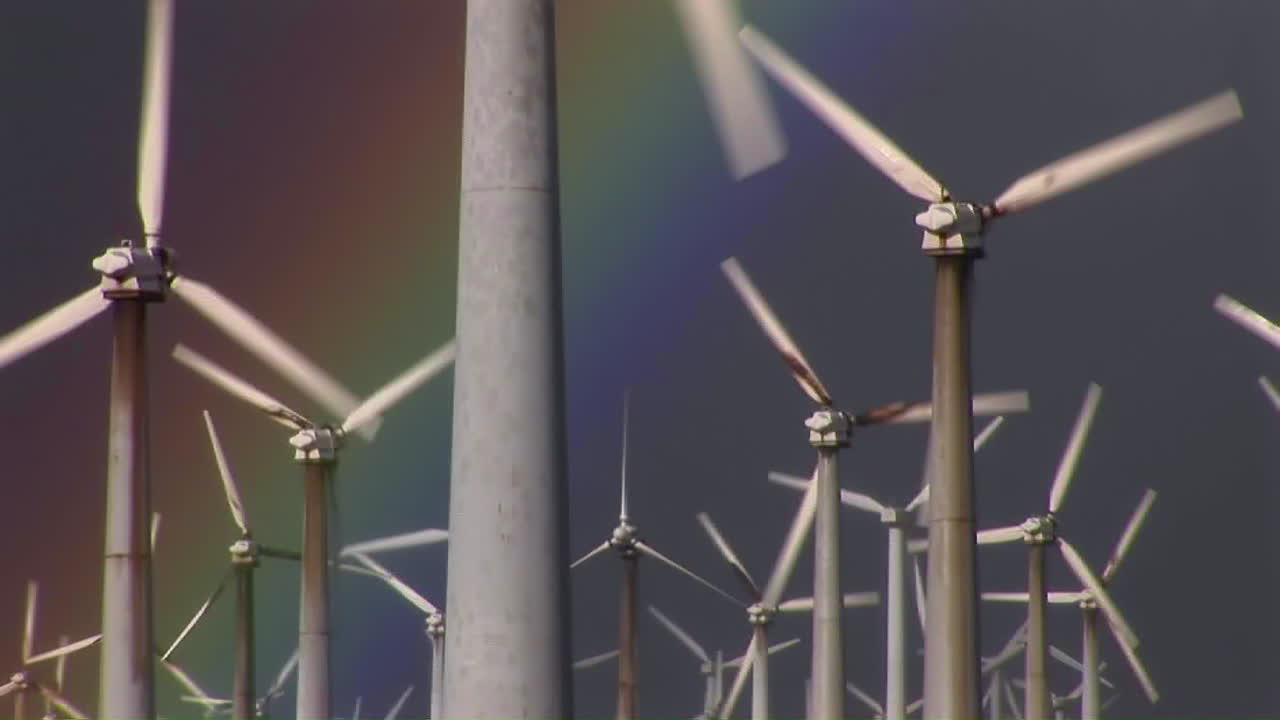 화려한 무지개가 회전하는 풍력 발전기를 비추도록 기울입니다.