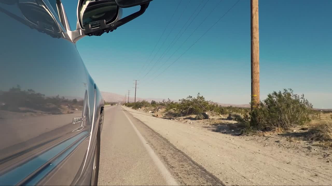 Driving on an open road through the deser in Southern California near Joshua Tree National Park on a sunny day