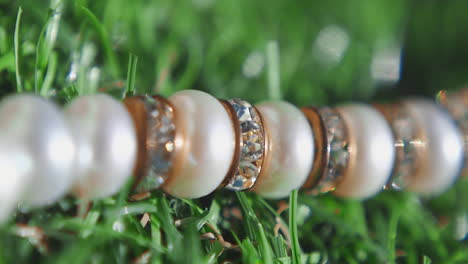 stylish necklace with pearls and gems on artificial grass