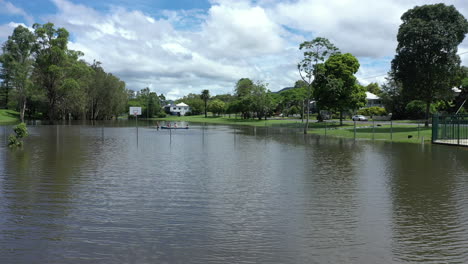 Toma-De-Dron-De-4k-De-Una-Cancha-De-Baloncesto-Inundada-Y-Un-Parque-Infantil-En-La-Pequeña-Ciudad-De-Murwillumbah,-Australia