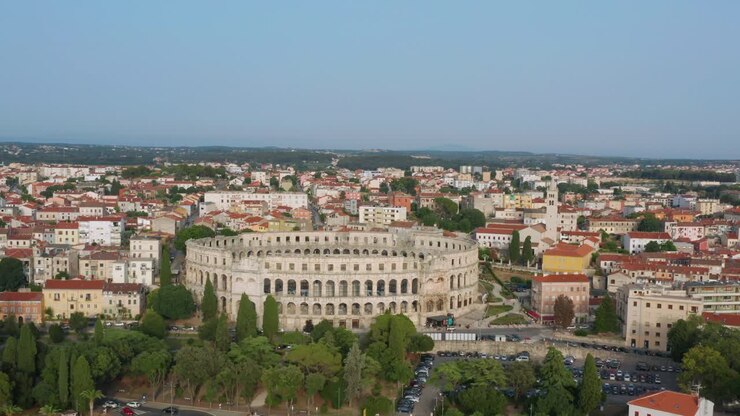 Ripresa aerea ad arco che circonda l'Arena di Pola a Pola, Croazia nel pomeriggio
