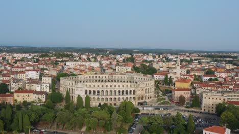 aerial arc shot circling around pula arena in pula, croatia in the afternoon