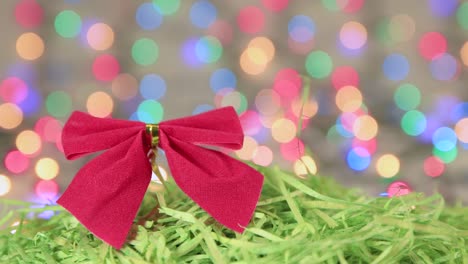 red christmas bow on green tinsel, new year background.