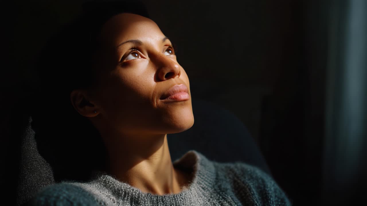 A Serene Moment of Reflection: A Focused Individual Enjoys the Warm Glow of Natural Light While Sitting Comfortably in a Cozy Sweater, Evoking Calm and Peacefulness