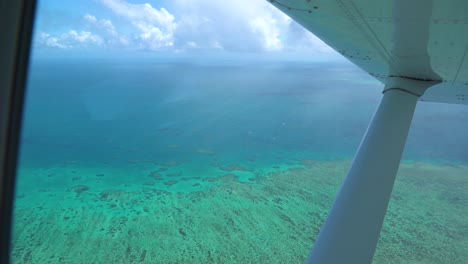 Gran-Barrera-De-Coral-Vuelo-Panorámico-Disparo-Aéreo-Desde-La-Ventana-Del-Avión