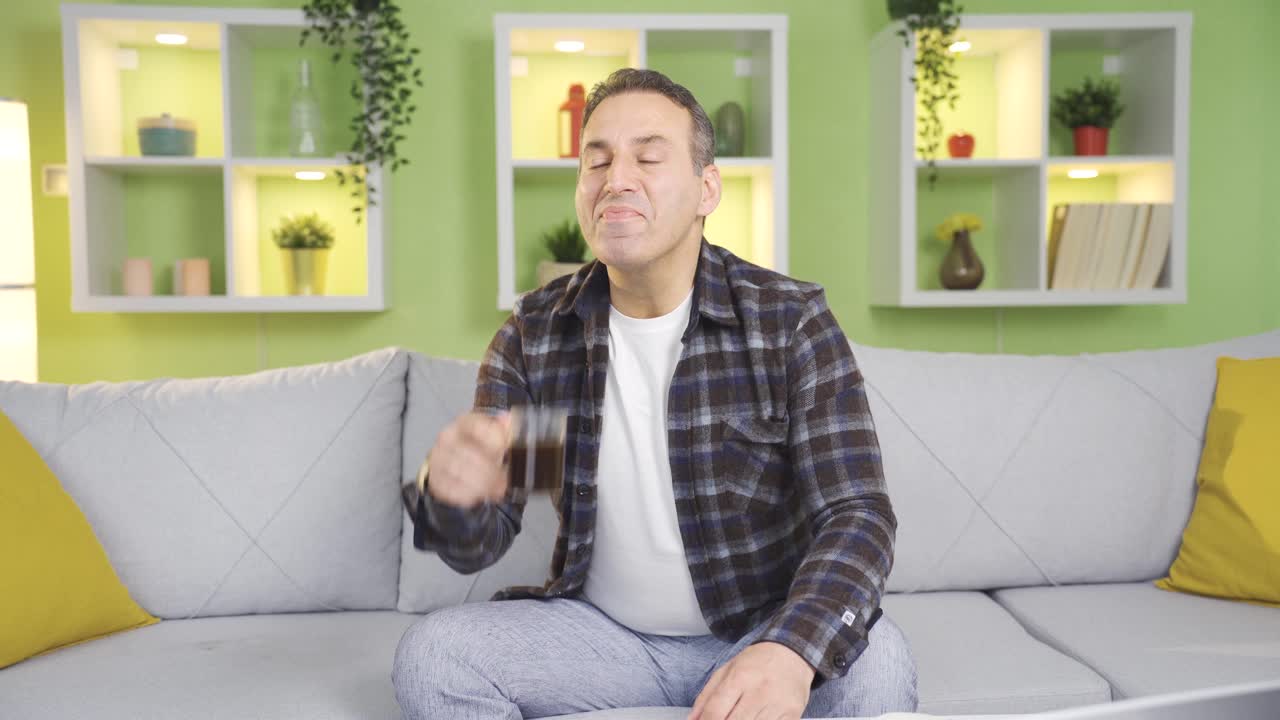 쾌적하고 평화로운 행복한 사람이 집에서 뜨거운 커피를 마시고 있습니다.