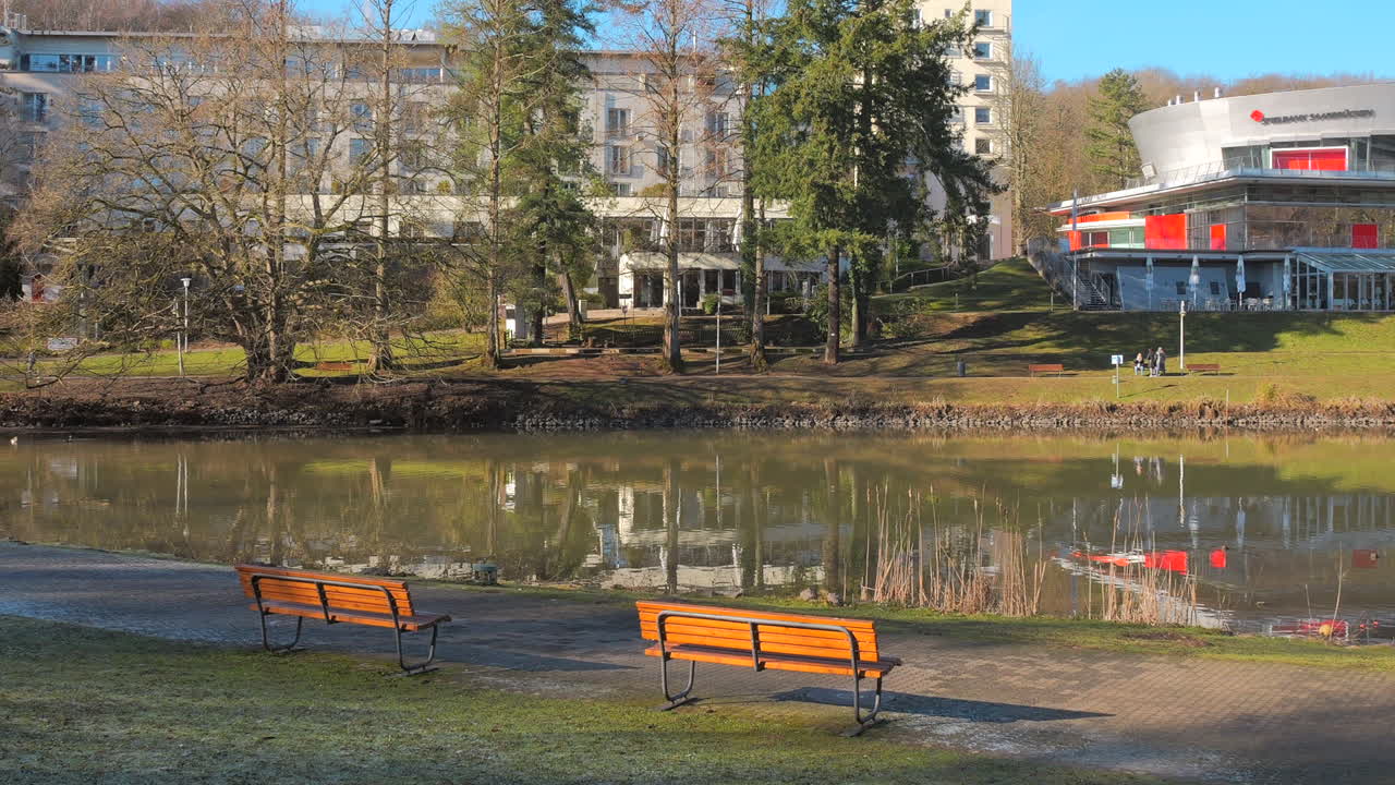 Riverside view with park benches and buildings in Saarbrücken