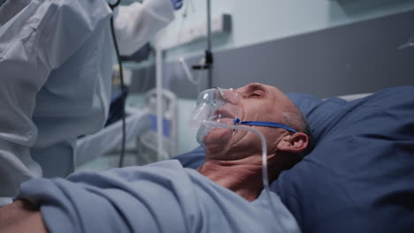 medical professional examining patient with oxygen mask in hospital