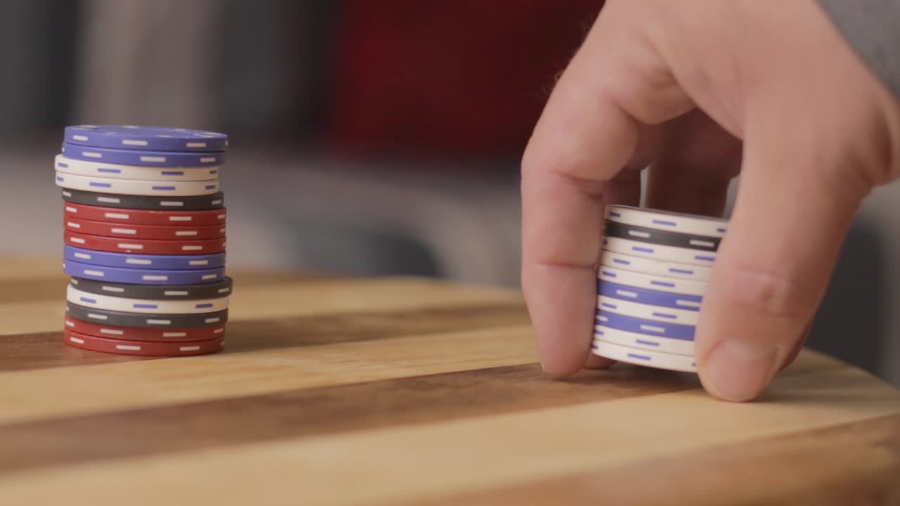 pan left close up of man pushing stack of poker chips